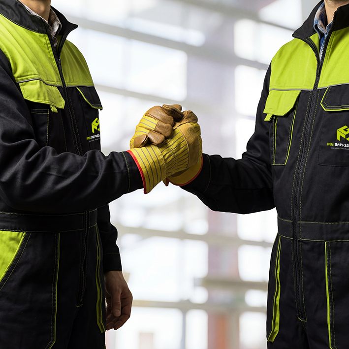 Stretta di mano tra operai MG Impresa Edile in cantiere